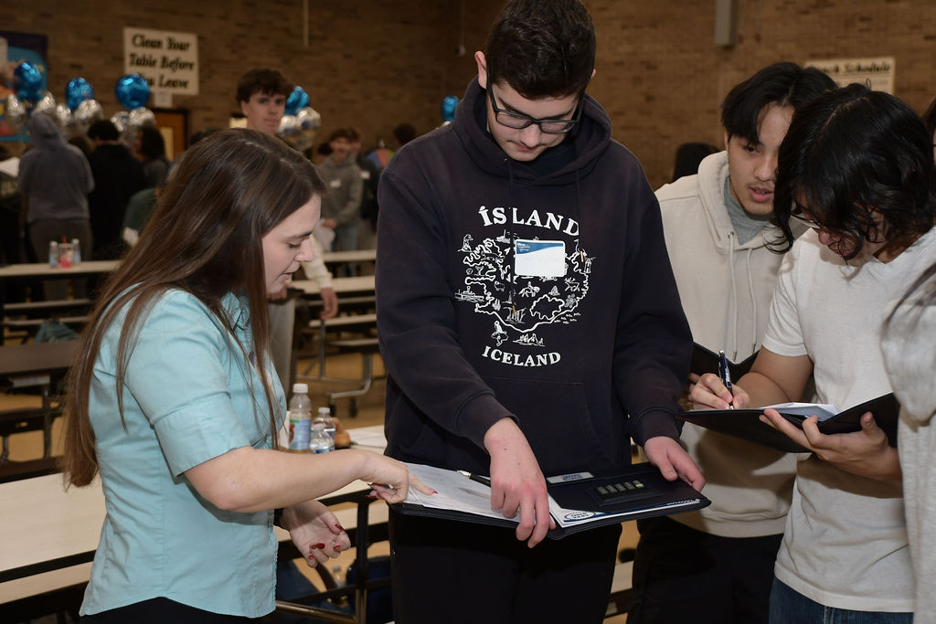 Kelsey DiCarlo, Wave FCU Branch Supervisor, with students answering budget questions.