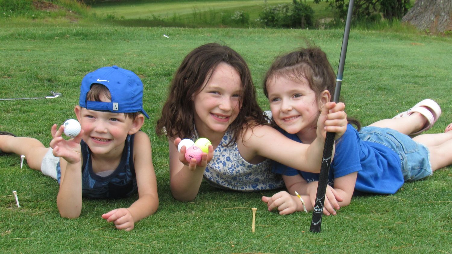 Kids laying next to golf hole